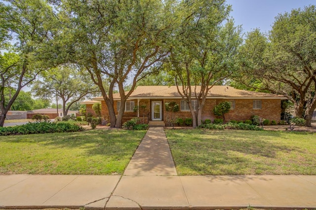 ranch-style home with brick siding and a front lawn