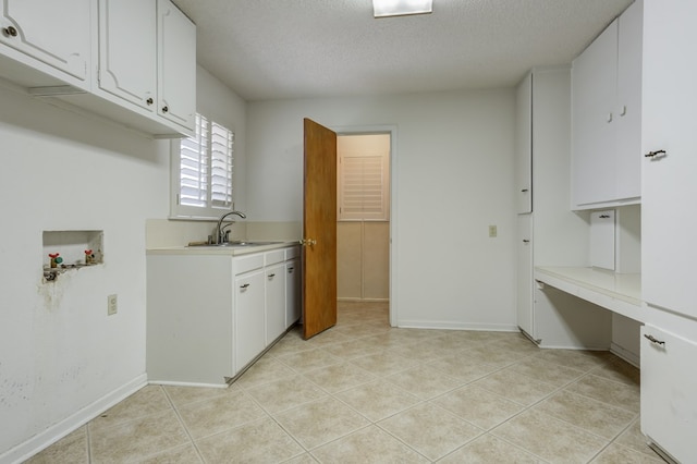 washroom with a sink, cabinet space, a textured ceiling, light tile patterned floors, and washer hookup