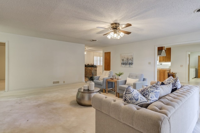 living area featuring a textured ceiling, visible vents, a fireplace, light carpet, and a ceiling fan