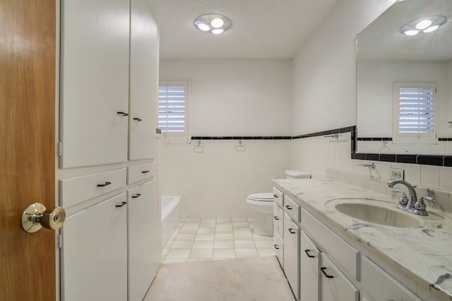 bathroom with toilet, tile walls, plenty of natural light, and tile patterned floors