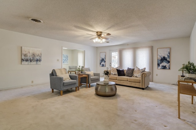 carpeted living room featuring baseboards, visible vents, ceiling fan, and a textured ceiling