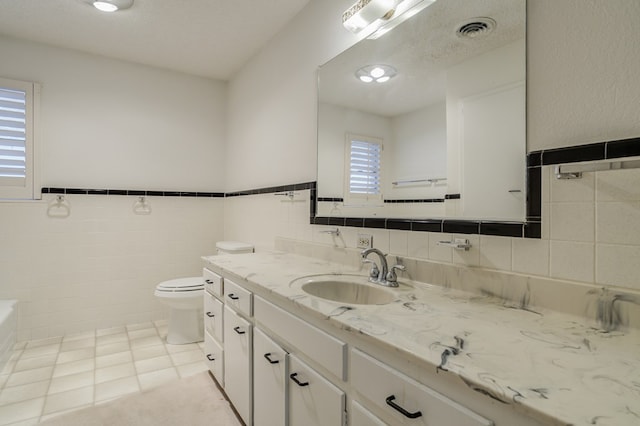 full bathroom featuring tile walls, tile patterned floors, visible vents, and a wealth of natural light