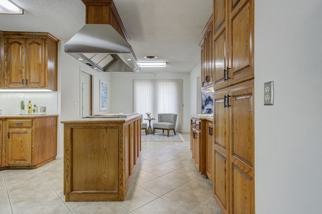 kitchen featuring a textured ceiling, decorative backsplash, brown cabinets, and light tile patterned floors