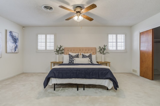 bedroom featuring carpet floors, visible vents, and multiple windows