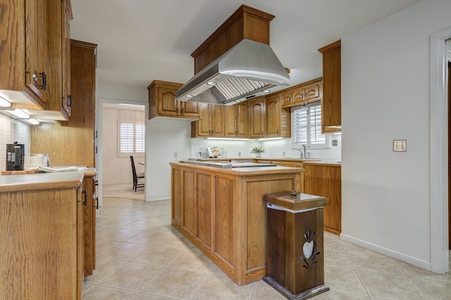 kitchen featuring light tile patterned floors, brown cabinetry, and backsplash