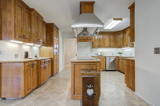 kitchen with a center island, island exhaust hood, brown cabinetry, stainless steel dishwasher, and backsplash