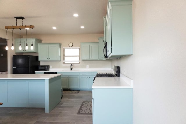 kitchen featuring black appliances, dark wood-type flooring, sink, and hanging light fixtures