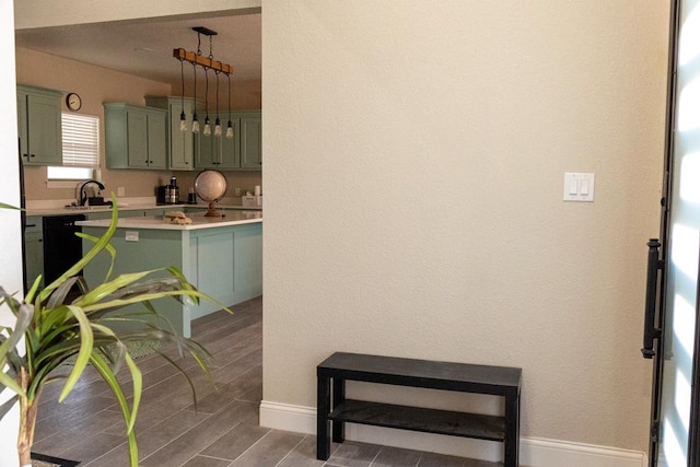 kitchen featuring sink, black dishwasher, and green cabinetry