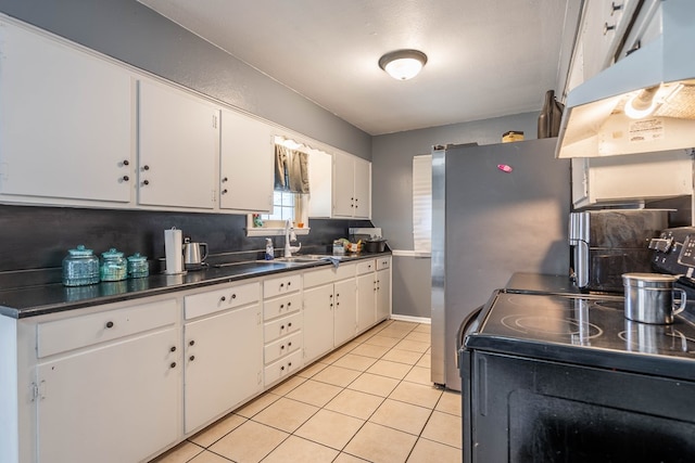 kitchen with sink, electric range, tasteful backsplash, light tile patterned flooring, and white cabinetry