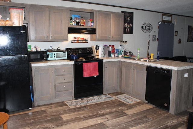 2711 W 83rd St, Odessa, TX 79764 - kitchen featuring black appliances, a peninsula, under cabinet range hood, wood finished floors, and ornamental molding