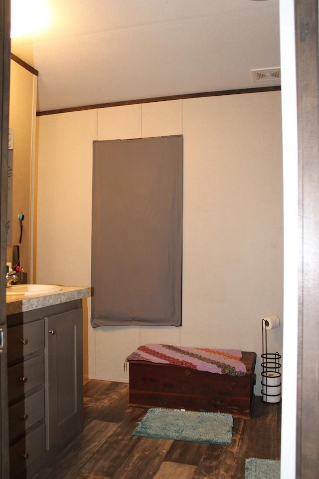 2711 W 83rd St, Odessa, TX 79764 - bathroom featuring wood finished floors, vanity, and ornamental molding