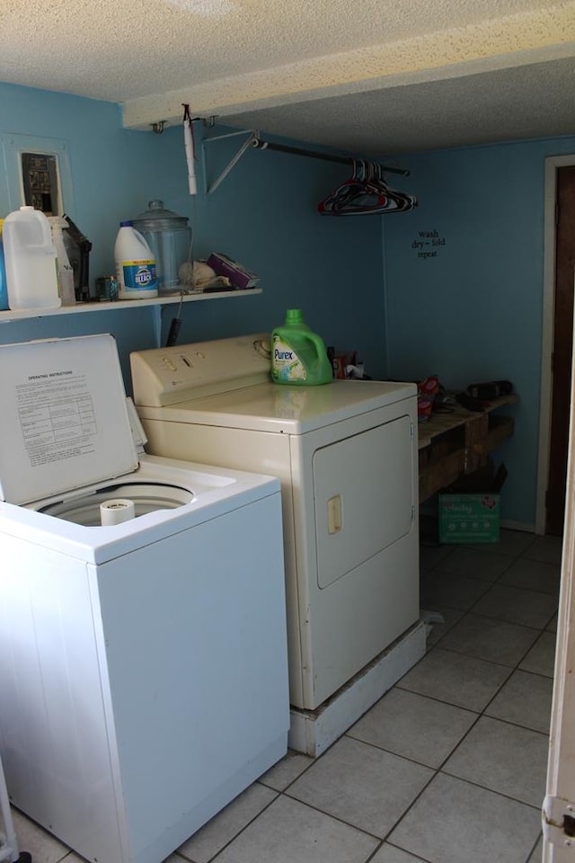 2711 W 83rd St, Odessa, TX 79764 - washroom with washing machine and clothes dryer, light tile patterned flooring, and a textured ceiling