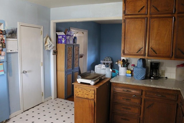 2711 W 83rd St, Odessa, TX 79764 - kitchen featuring decorative backsplash, light countertops, freestanding refrigerator, and light flooring