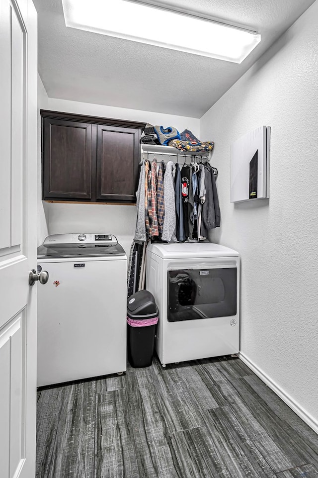 laundry area with washing machine and dryer, cabinet space, dark wood-style floors, and a textured wall