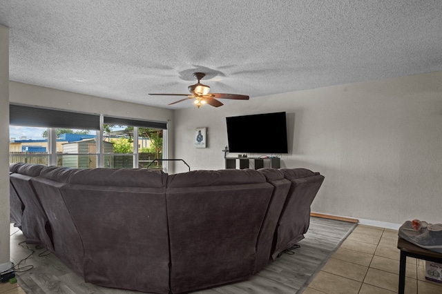 2110 Redbud Ave, Odessa, TX 79761 - living room featuring a ceiling fan, baseboards, tile patterned floors, and a textured ceiling