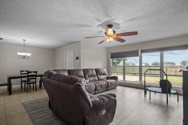 2110 Redbud Ave, Odessa, TX 79761 - living room with a chandelier, ceiling fan, and a textured ceiling
