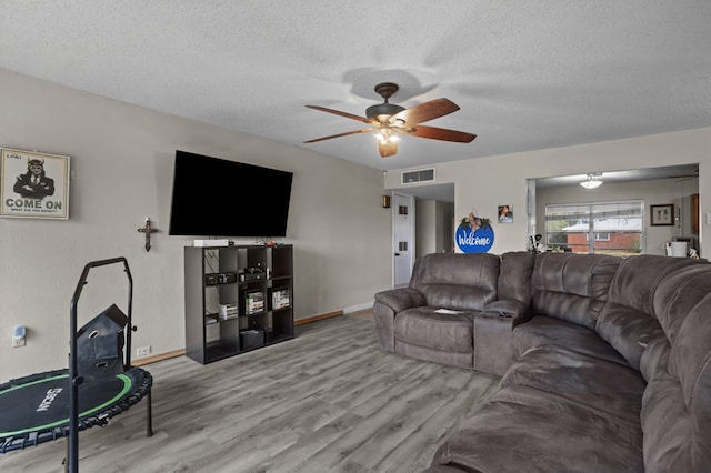 2110 Redbud Ave, Odessa, TX 79761 - living area featuring a textured ceiling, ceiling fan, wood finished floors, and baseboards