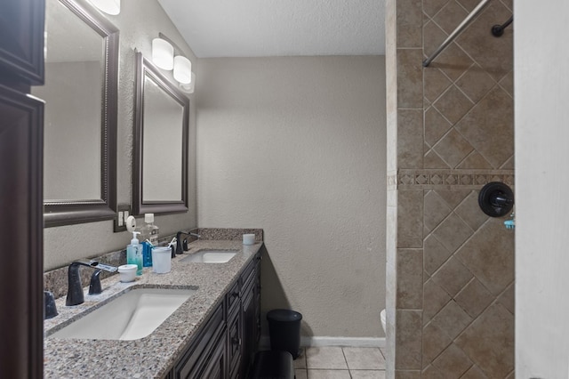 2110 Redbud Ave, Odessa, TX 79761 - full bath with double vanity, tile patterned flooring, tiled shower, and baseboards