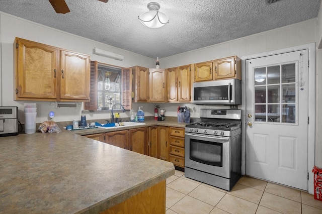 2110 Redbud Ave, Odessa, TX 79761 - kitchen with stainless steel appliances, a sink, a textured ceiling, light tile patterned floors, and a ceiling fan