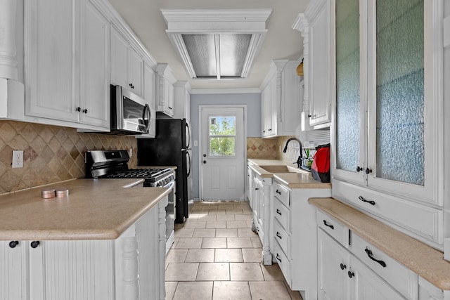 1306 Woodlawn Dr, Odessa, TX 79761 - kitchen with stainless steel microwave, gas range oven, white cabinetry, and light countertops