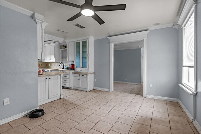 1306 Woodlawn Dr, Odessa, TX 79761 - kitchen with a ceiling fan, light countertops, white cabinets, decorative backsplash, and glass insert cabinets