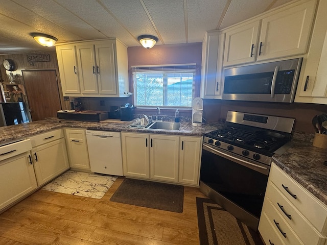303 Squaw Valley Trl, Fort Davis, TX 79734 - kitchen featuring appliances with stainless steel finishes, light wood-style floors, white cabinets, and a textured ceiling