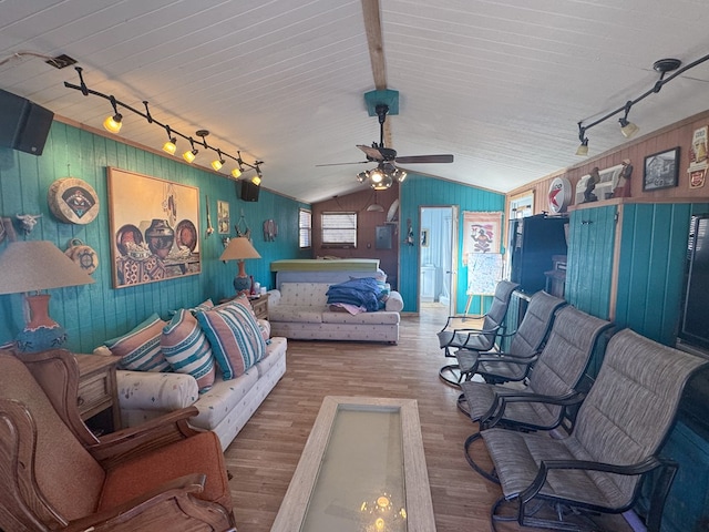 303 Squaw Valley Trl, Fort Davis, TX 79734 - living room with rail lighting, wood walls, vaulted ceiling, wood finished floors, and a ceiling fan