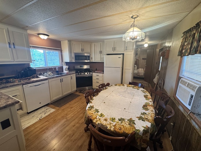 303 Squaw Valley Trl, Fort Davis, TX 79734 - kitchen featuring appliances with stainless steel finishes, dark countertops, wood finished floors, a chandelier, and a textured ceiling