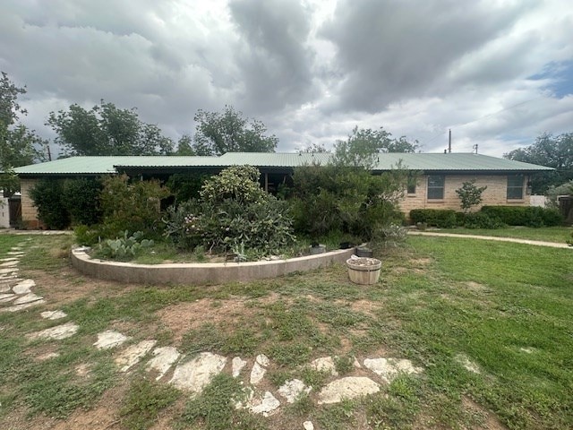 407 N Phelps St, Alpine, TX 79830 - rear view of property featuring a lawn and metal roof