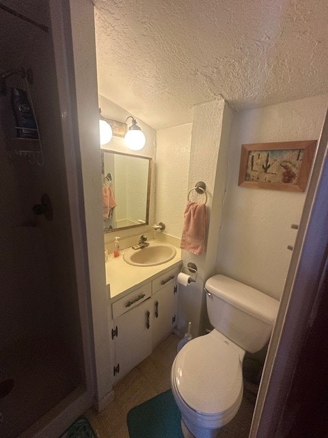 407 N Phelps St, Alpine, TX 79830 - bathroom with toilet, vanity, a textured ceiling, and a shower stall