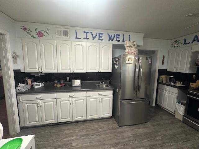 407 N Phelps St, Alpine, TX 79830 - kitchen with appliances with stainless steel finishes, a sink, white cabinetry, and dark countertops