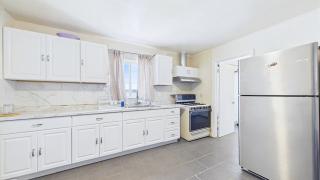 912 W 7th St, Pecos, TX 79772 - kitchen with freestanding refrigerator, white gas range, and white cabinets