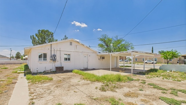 912 W 7th St, Pecos, TX 79772 - rear view of property featuring a carport