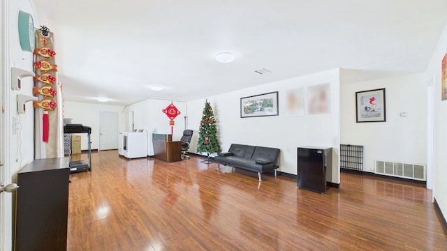 912 W 7th St, Pecos, TX 79772 - living area with washer / clothes dryer, wood finished floors, and radiator heating unit