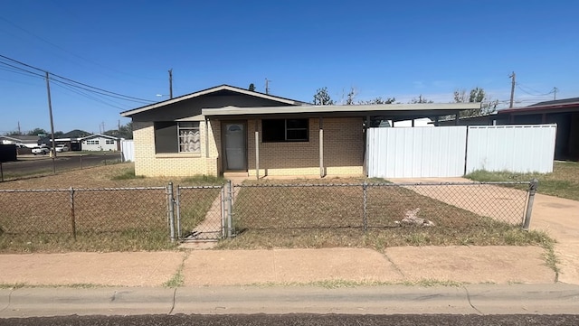 3501 Merrill Ave, Odessa, TX 79764 - bungalow-style home with a fenced front yard, brick siding, a gate, a carport, and driveway