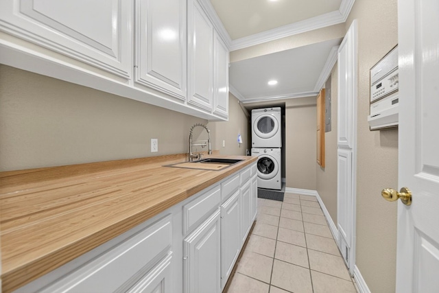 2720 Fair Oaks Cir, Odessa, TX 79762 - laundry room featuring estacked washer and dryer, ornamental molding, light tile patterned floors, cabinet space, and recessed lighting