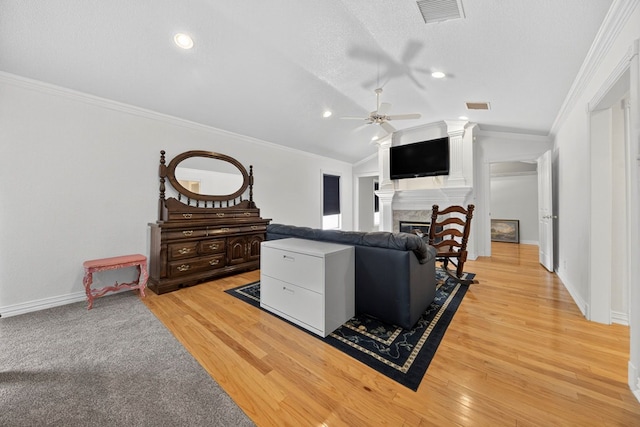 2720 Fair Oaks Cir, Odessa, TX 79762 - living room featuring ceiling fan, lofted ceiling, ornamental molding, light wood-style flooring, and a glass covered fireplace
