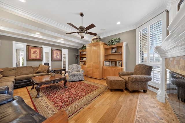 2720 Fair Oaks Cir, Odessa, TX 79762 - living room featuring a ceiling fan, crown molding, a tiled fireplace, light wood-style flooring, and recessed lighting