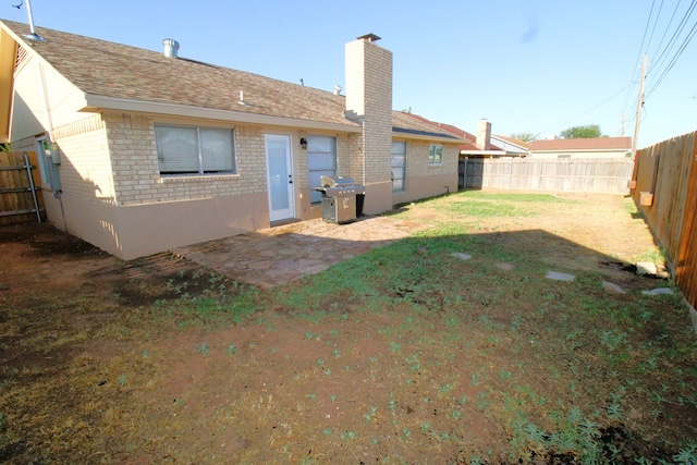 1721 E 56th St, Odessa, TX 79762 - back of property featuring brick siding, a chimney, roof with shingles, and a patio area