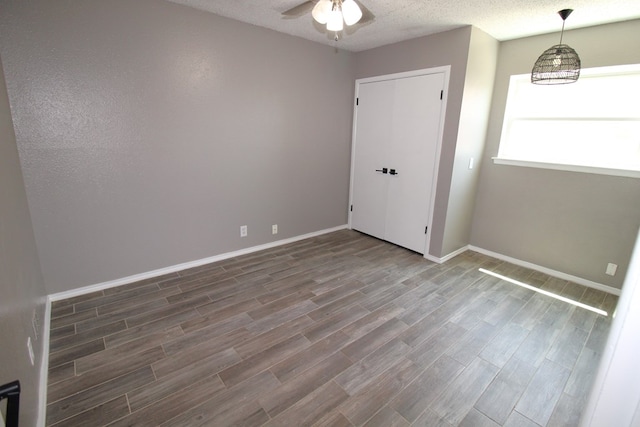 1721 E 56th St, Odessa, TX 79762 - unfurnished bedroom with wood finished floors, baseboards, and a textured ceiling