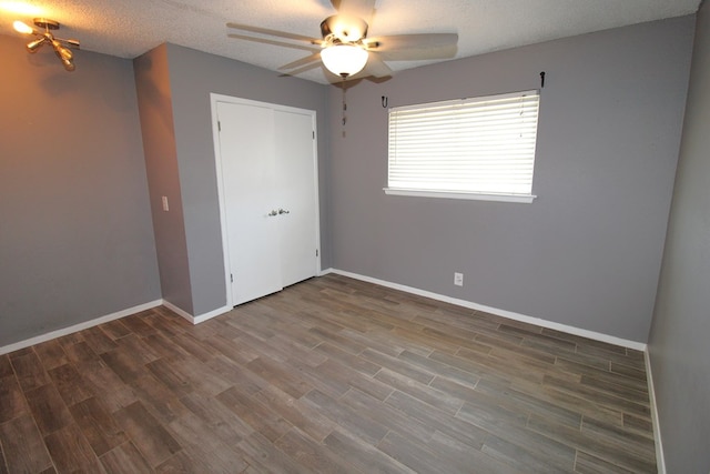 1721 E 56th St, Odessa, TX 79762 - unfurnished bedroom featuring wood finished floors, baseboards, a closet, ceiling fan, and a textured ceiling