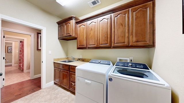 1006 W Cuthbert Ave, Midland, TX 79701 - laundry area featuring independent washer and dryer, cabinet space, and light tile patterned floors