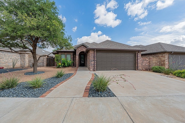 1006 W Cuthbert Ave, Midland, TX 79701 - view of front facade with an attached garage, brick siding, driveway, and a shingled roof
