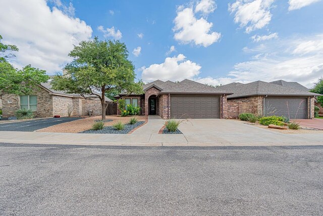 1006 W Cuthbert Ave, Midland, TX 79701 - view of front of home with a garage, brick siding, and driveway