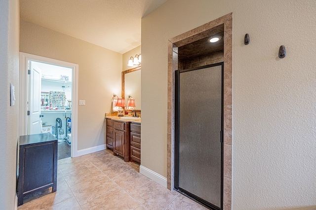 1006 W Cuthbert Ave, Midland, TX 79701 - bathroom with vanity, a stall shower, a textured wall, and tile patterned flooring