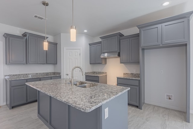 309 S Hancock Ave, Odessa, TX 79761 - kitchen featuring recessed lighting, an island with sink, under cabinet range hood, light stone counters, and gray cabinets