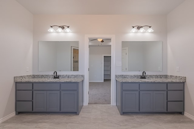 309 S Hancock Ave, Odessa, TX 79761 - bathroom with two vanities, ceiling fan, and marble look tiles