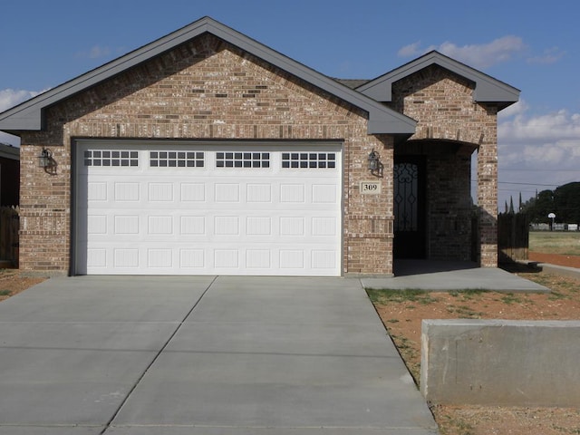 309 S Hancock Ave, Odessa, TX 79761 - view of front of house featuring brick siding, concrete driveway, and an attached garage