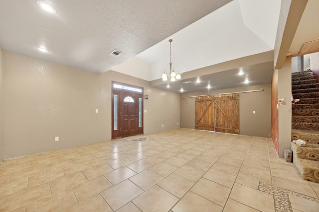 1321 Lindberg St, Odessa, TX 79763 - foyer with a barn door, a chandelier, stairway, vaulted ceiling, and light tile patterned floors