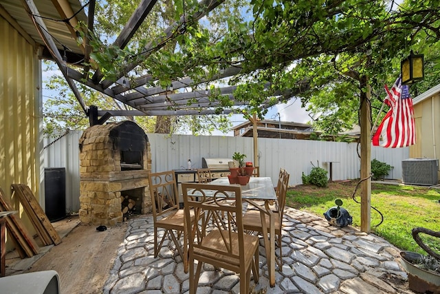 1321 Lindberg St, Odessa, TX 79763 - fenced backyard with an outdoor stone fireplace, a patio, area for grilling, a pergola, and outdoor dining space
